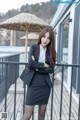 A woman in a business suit standing on a balcony.