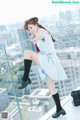 A woman in a school uniform posing on a balcony.