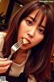 A woman eating a piece of cake with a fork.