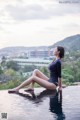 A woman sitting on the edge of a swimming pool.