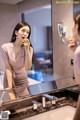 A woman brushing her teeth in front of a mirror.